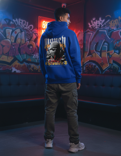 Person wearing a blue hoodie with graphic design in a graffiti-laden room